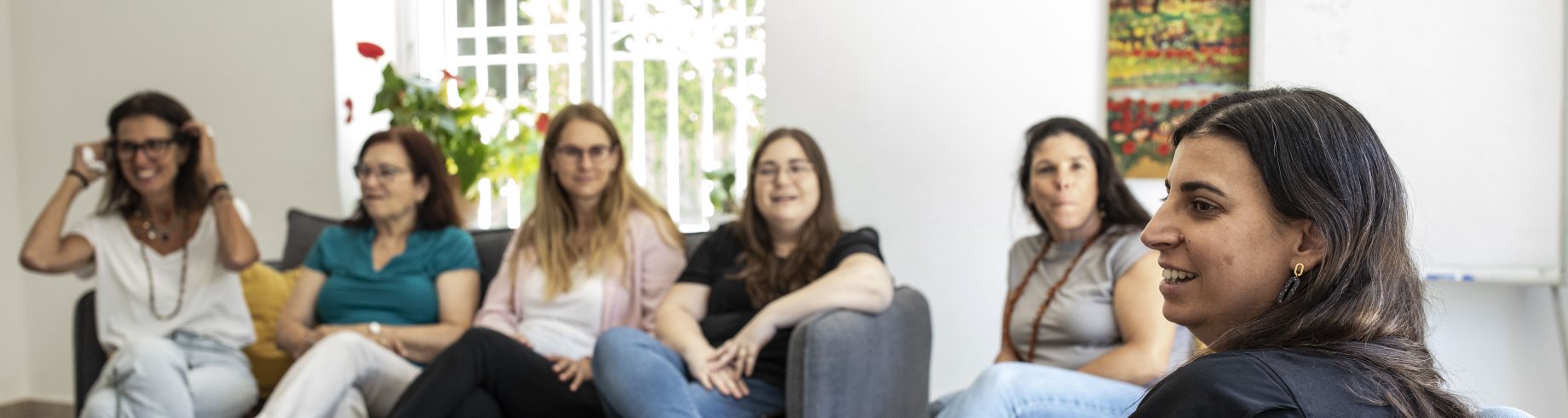 קבוצה של נשים יושבות על כורסאות במרכז סיוע