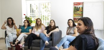 קבוצה של נשים יושבות על כורסאות במרכז סיוע